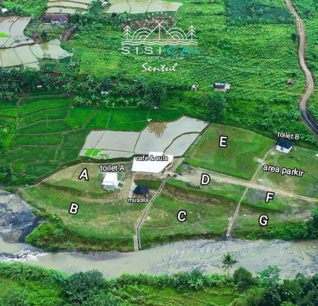 Foto udara Sisi Cai dengan label zona tenda A sampai G, toilet A dan B, musala, cafe dan aula, area parkir, serta sungai di sisi selatan